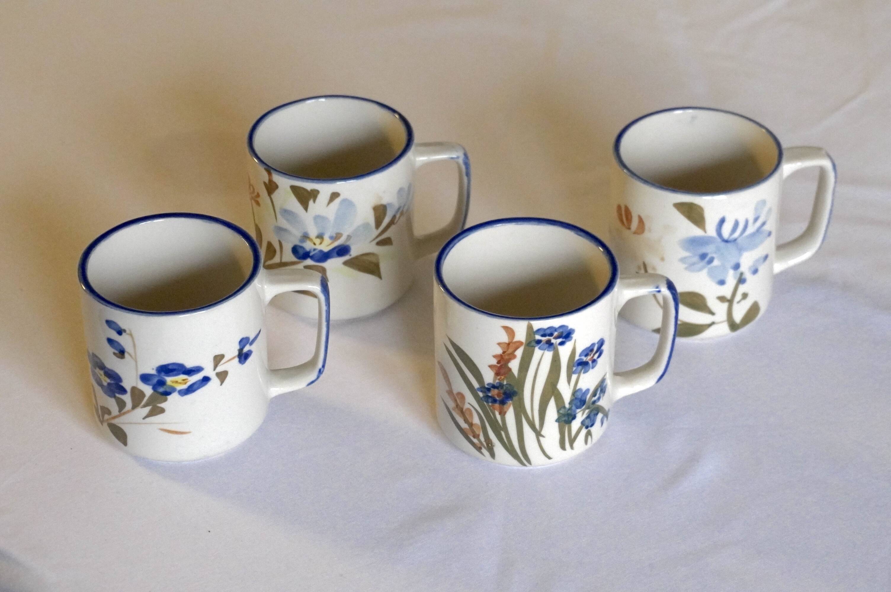 Set of 4 stoneware cups/mugs with blue floral designs, made in China.