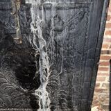 huge old fireplace plate has decoration of angels, crown and fleurs-de-lis