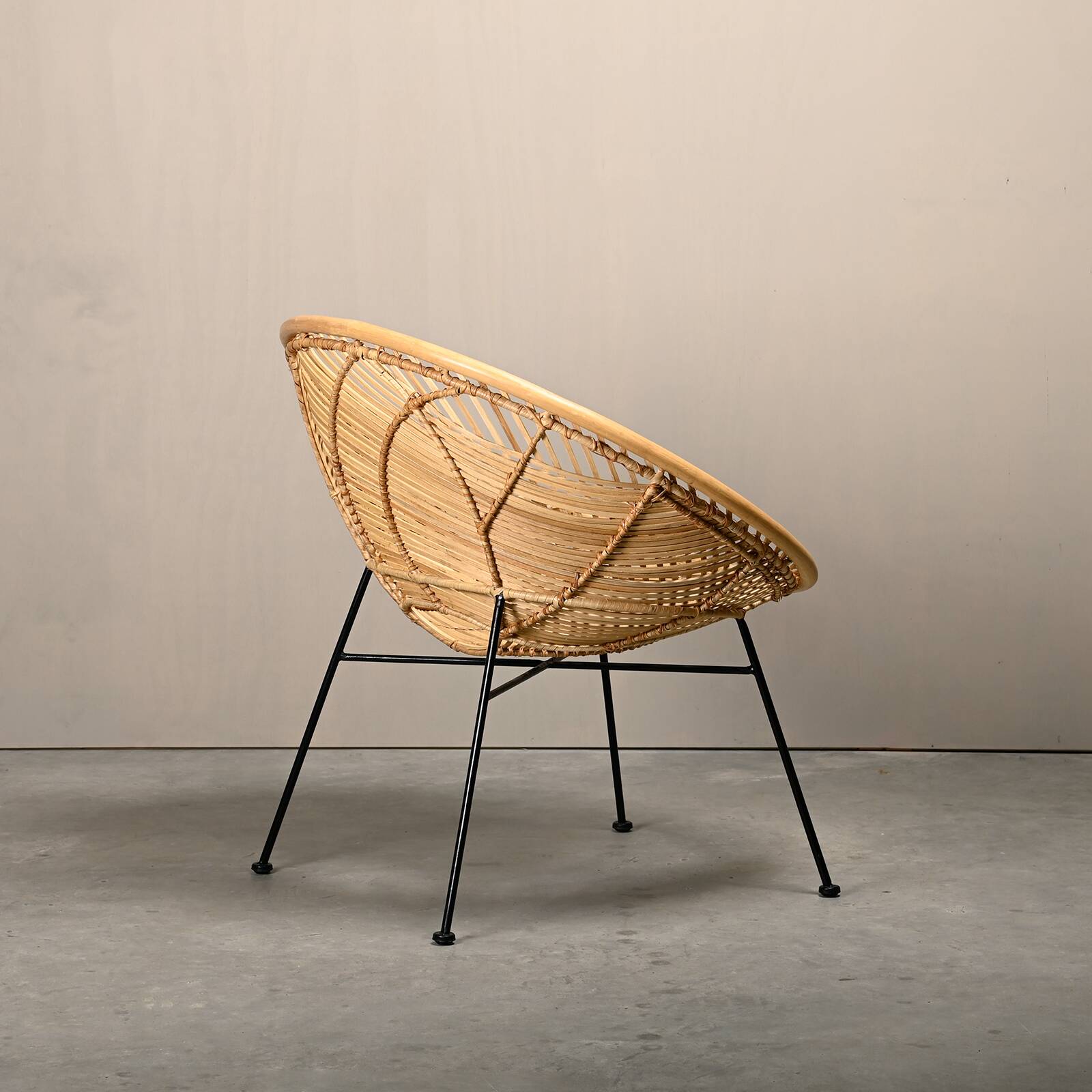 Round rattan lounge chair with black metal frame