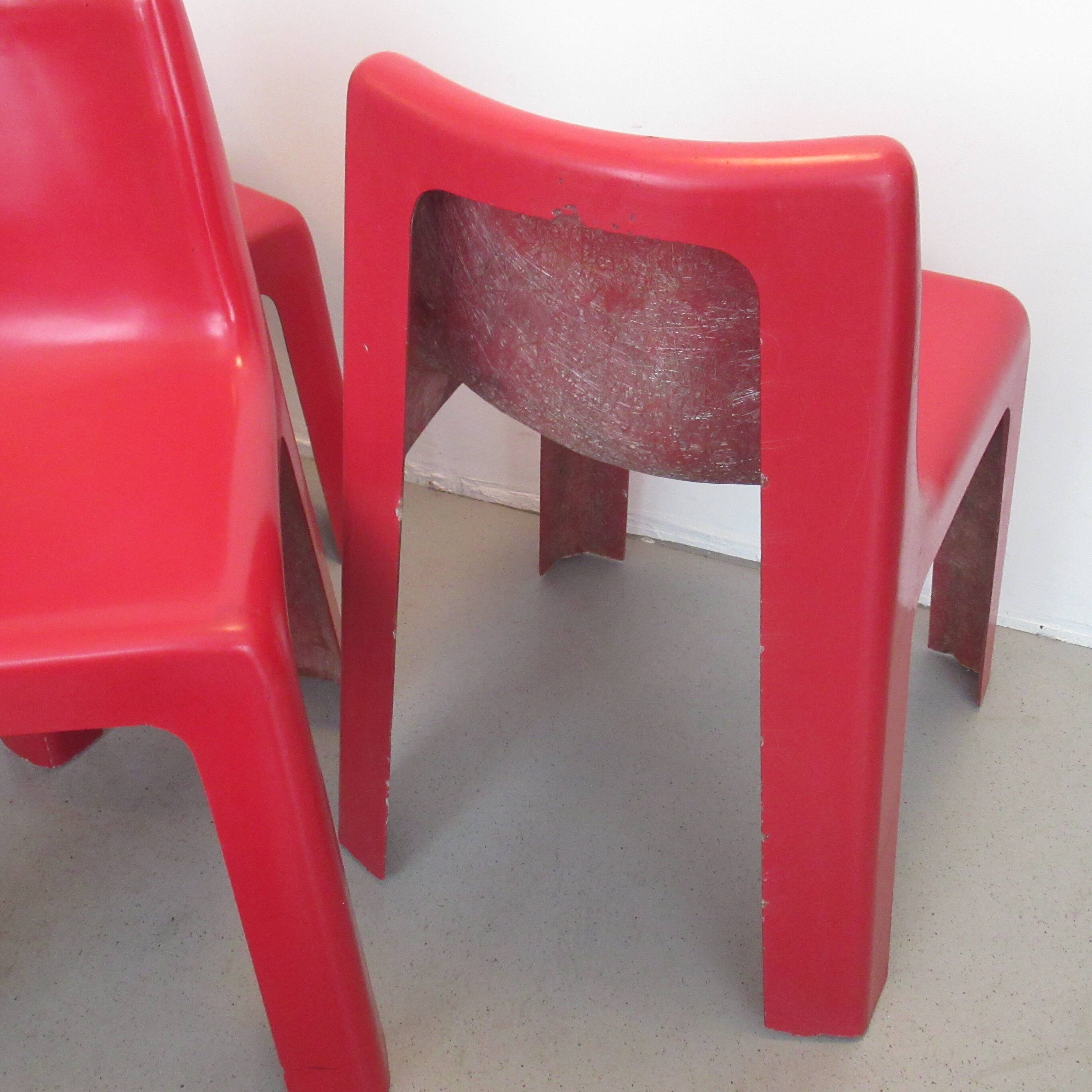 Four red fibreglass chairs from the 1970s.