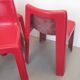 Four red fibreglass chairs from the 1970s.