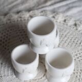 Vintage white porcelain egg cups with fruit motif.