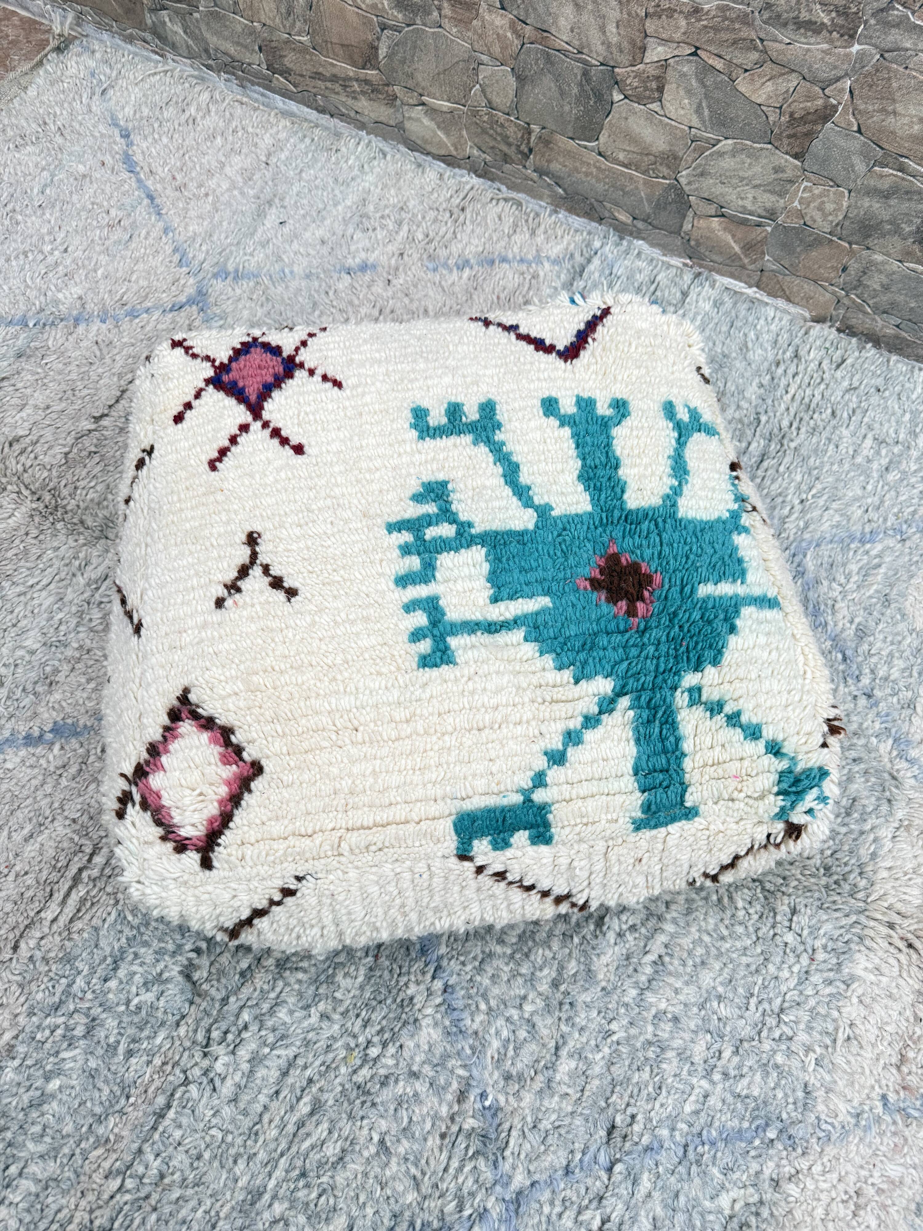 Berber floor pouf: Handwoven Moroccan wool cushion.