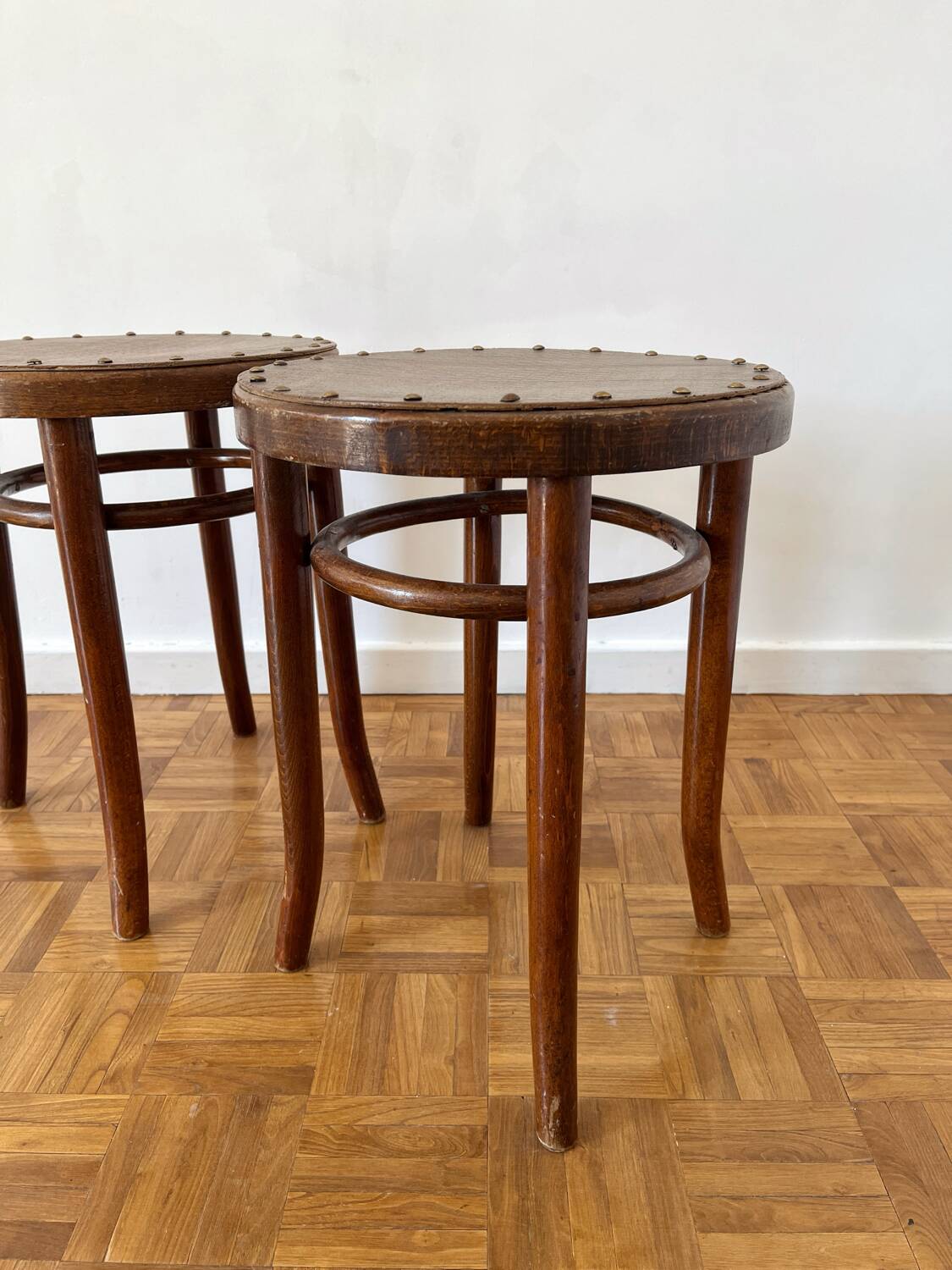 2 antique bistro stools with curved wood and caning effect.