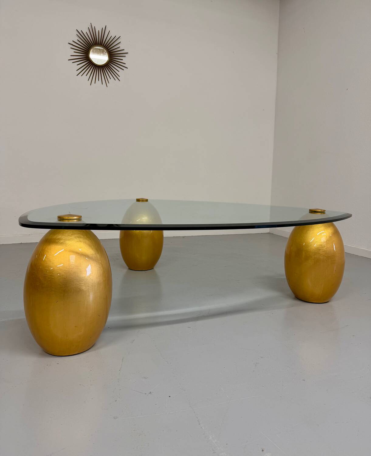 Vintage Italian design coffee table with a glass top and gold base, dating from the 1980s.
