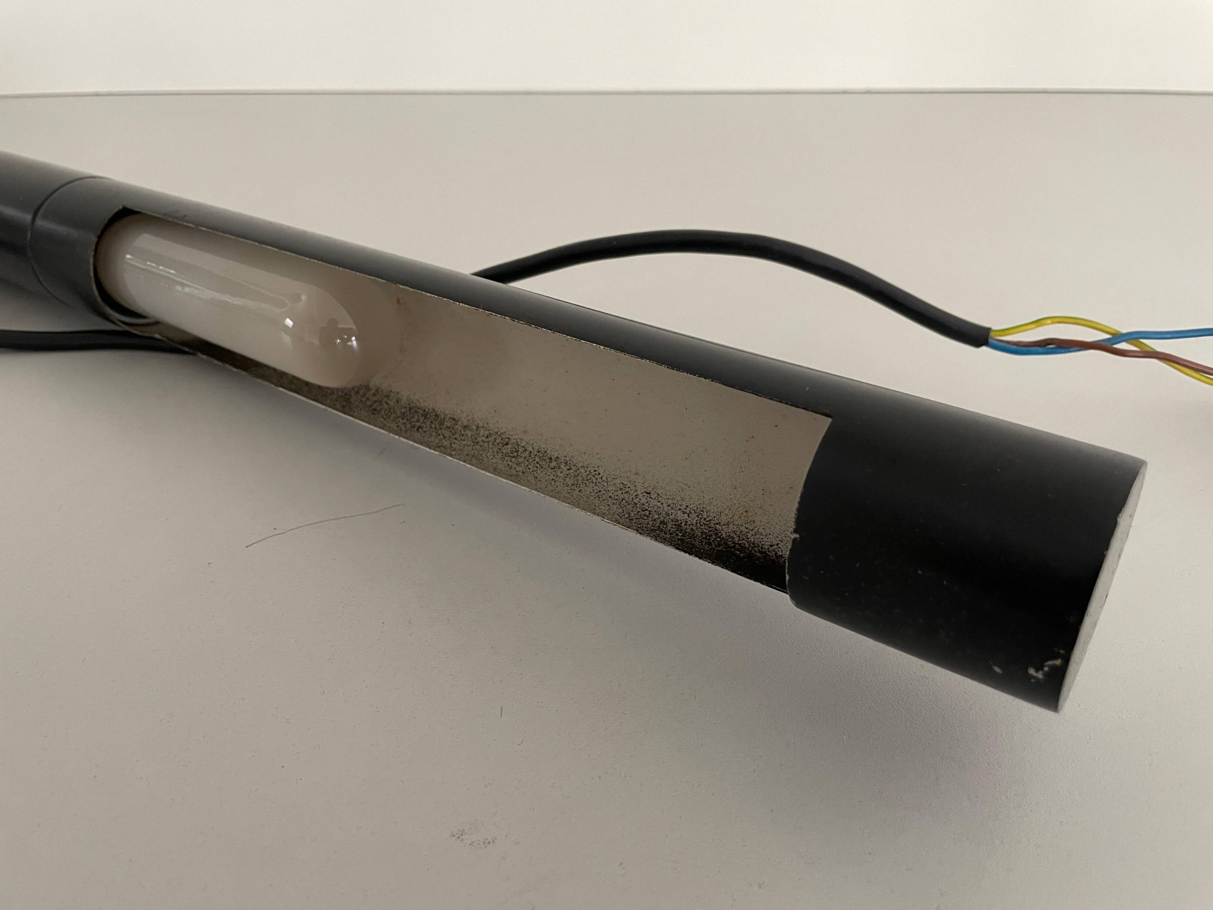 Minimalist black metal wall light with a cylindrical design, 1960s, Germany.