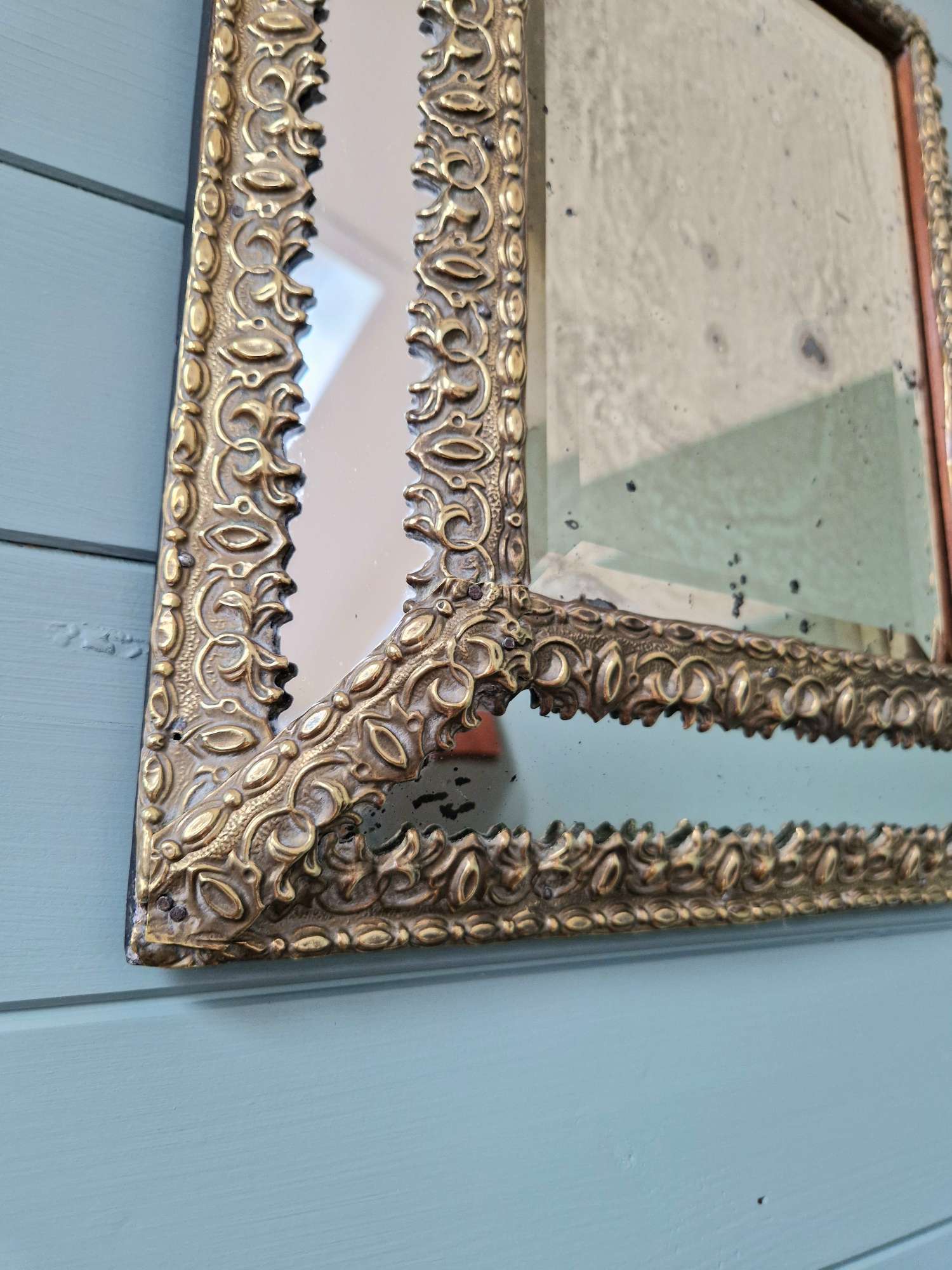 Mirror with repoussé brass frame, mercury glass, 19th century.