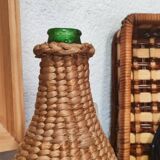 Green glass bottle and wickerwork