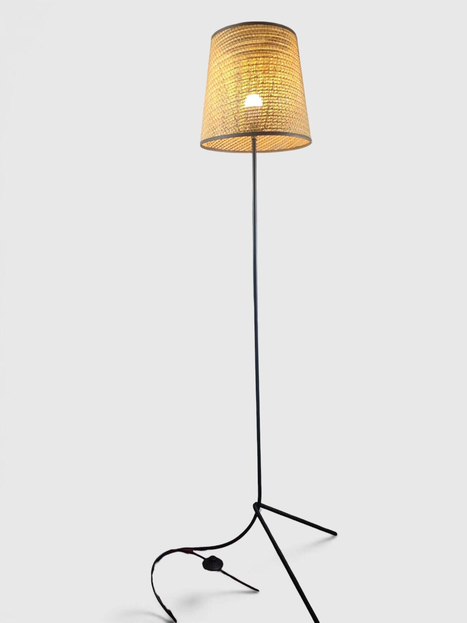 Modernist tripod floor lamp in black metal and cane from the 1950s/1960s.