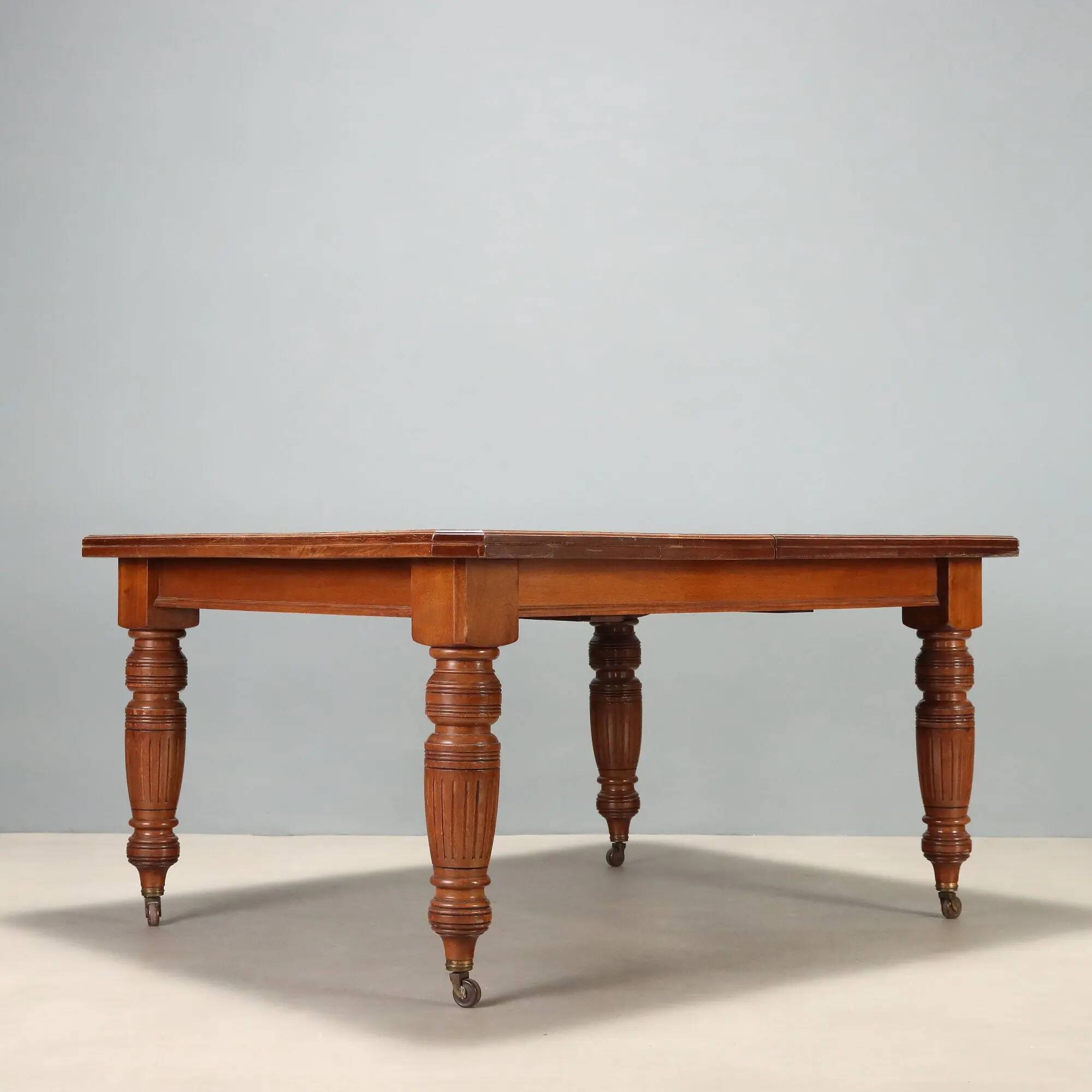 Antique extendable mahogany table with a crank mechanism, United Kingdom.