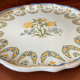 Plat rond ancien en faience de Lyon à décor de roses jaunes