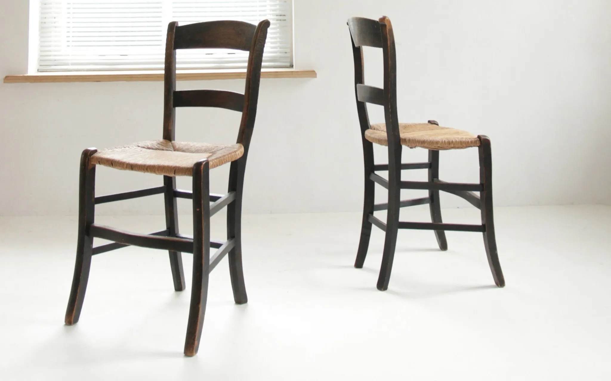 Pair of antique Northern French black-stained chairs with rush seats