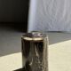 Black petrified wood side table with beige stripes and a semicircular shape.