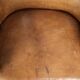 Antique armchair made of sheepskin and wood with decorative nails