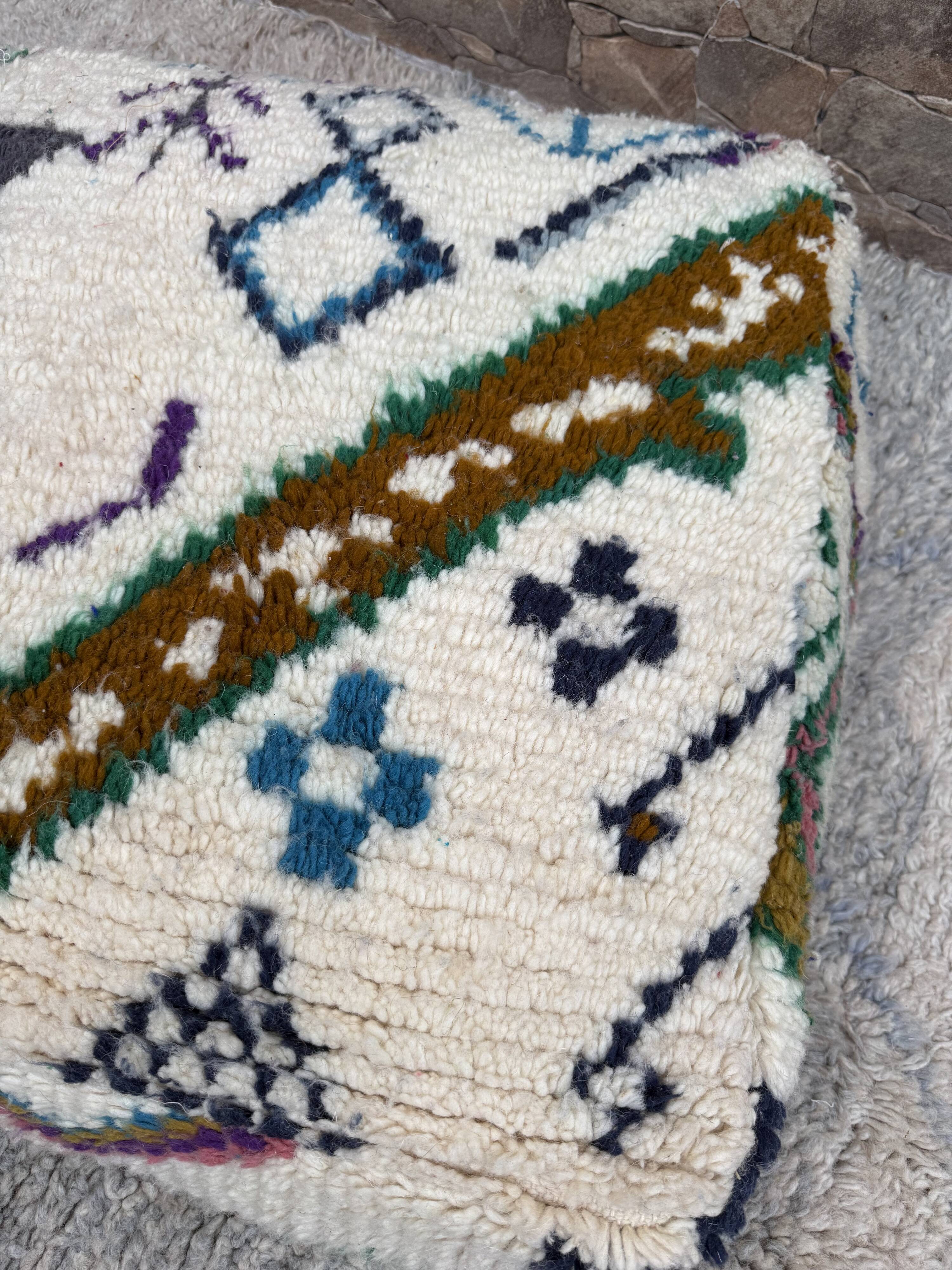 Berber floor pouf: Handwoven Moroccan wool cushion.
