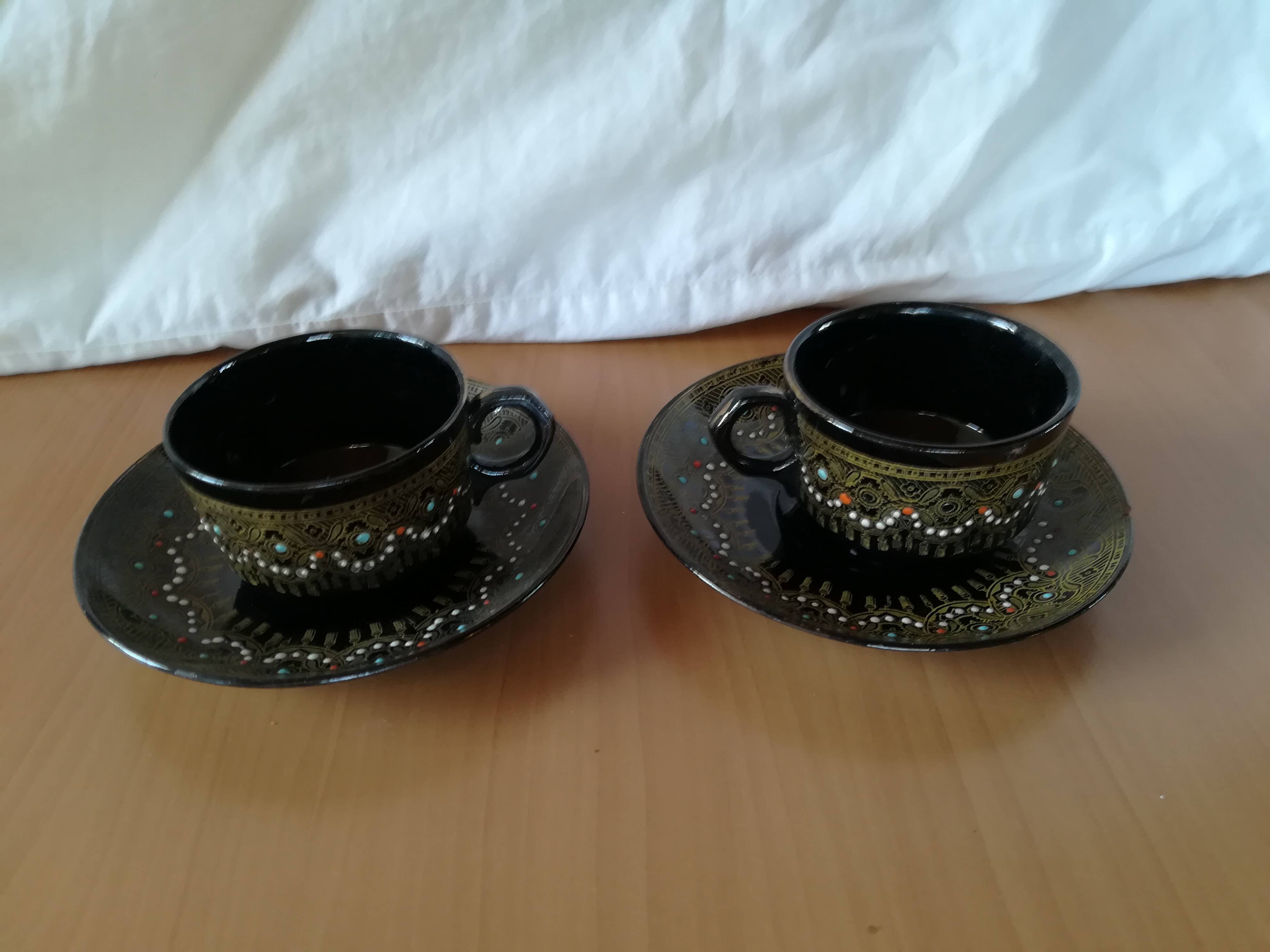 Black cups and saucers with relief decoration