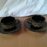 Black cups and saucers with relief decoration