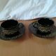 Black cups and saucers with relief decoration
