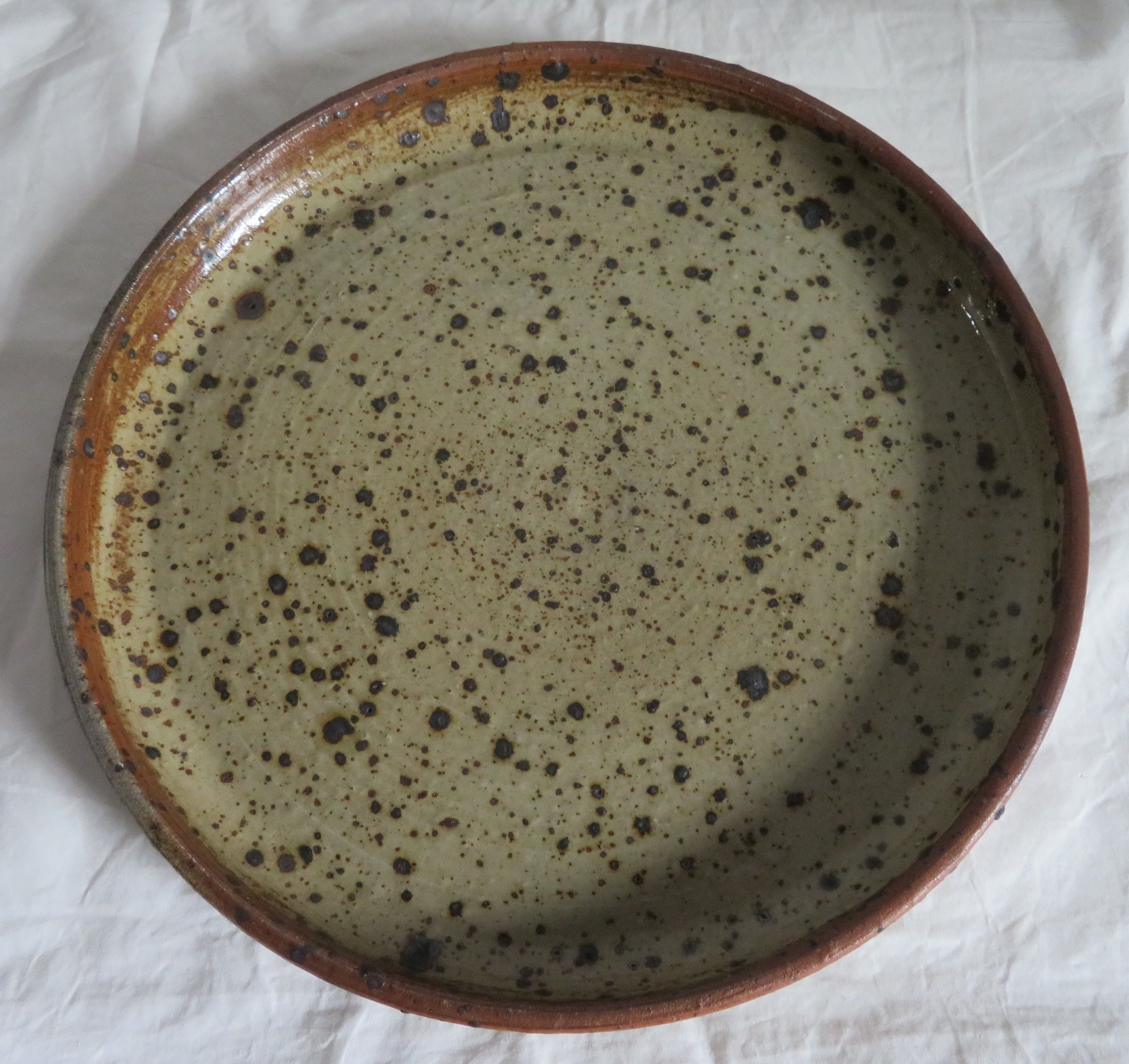 Round dish in varnished sandstone