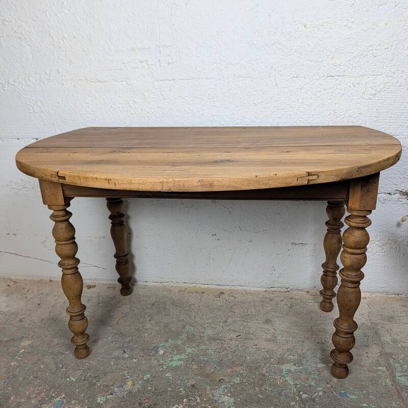Antique wooden drop-leaf table with turned legs.