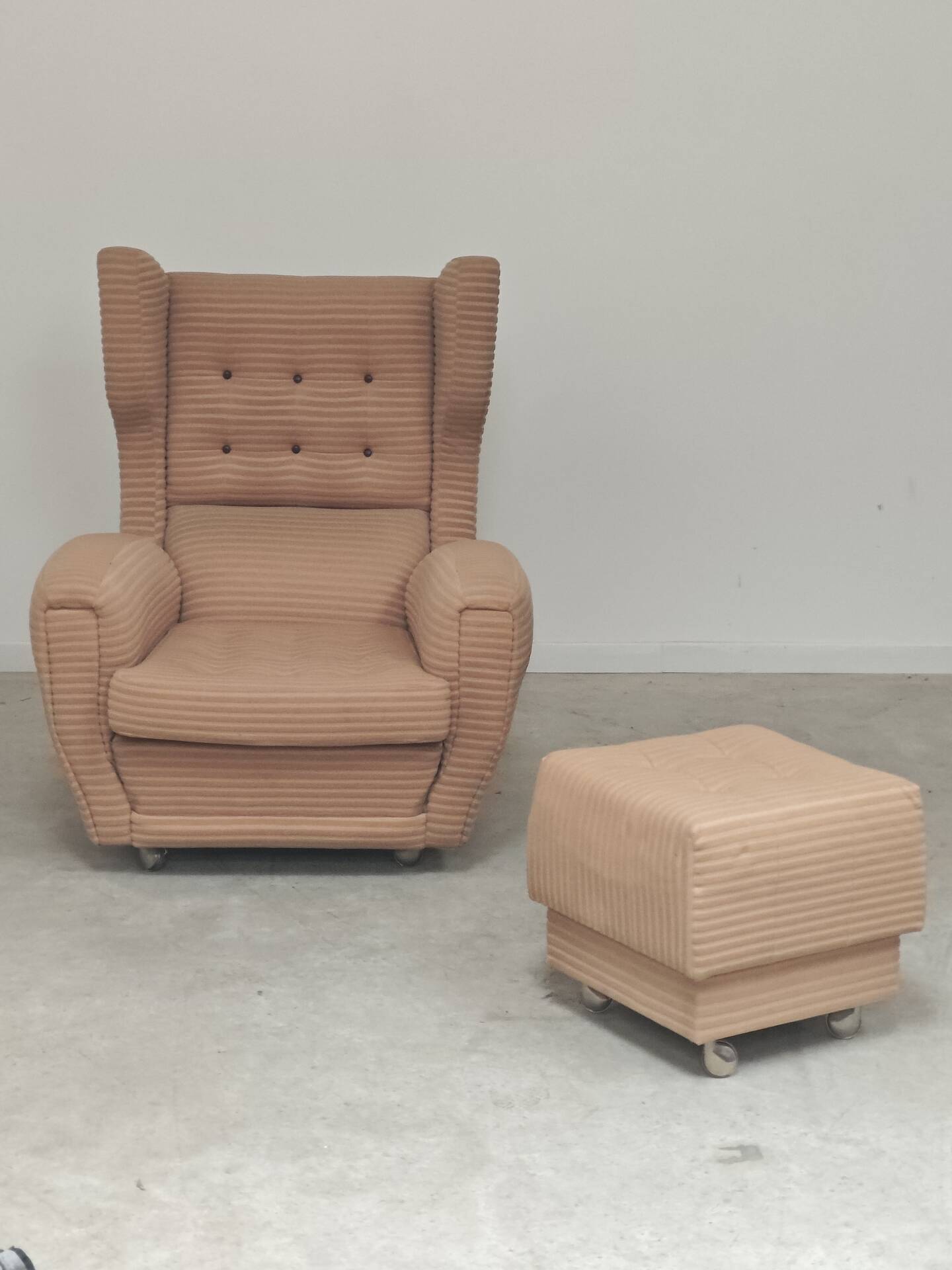 Beige wingback armchair and TVAR footrest, former Czechoslovakia.