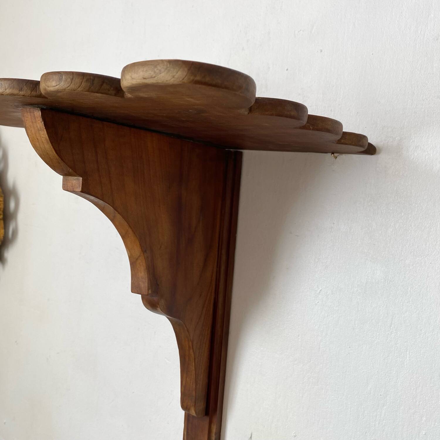 Antique wall shelf with a scalloped edge.