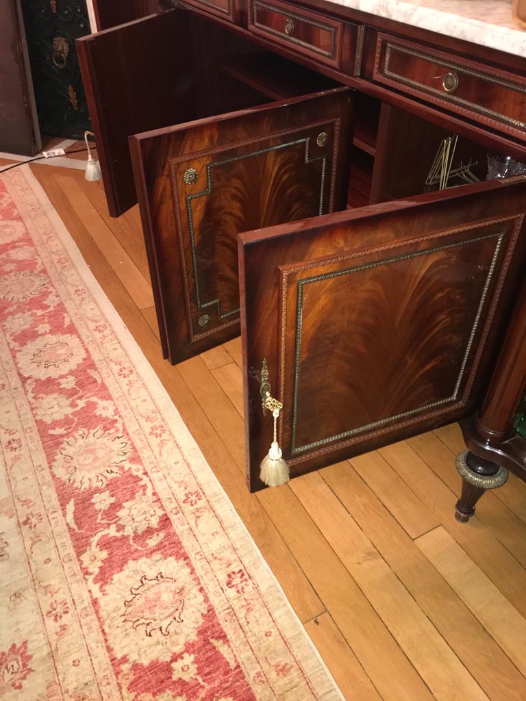 A mahogany buffet varnished with marble and bronze