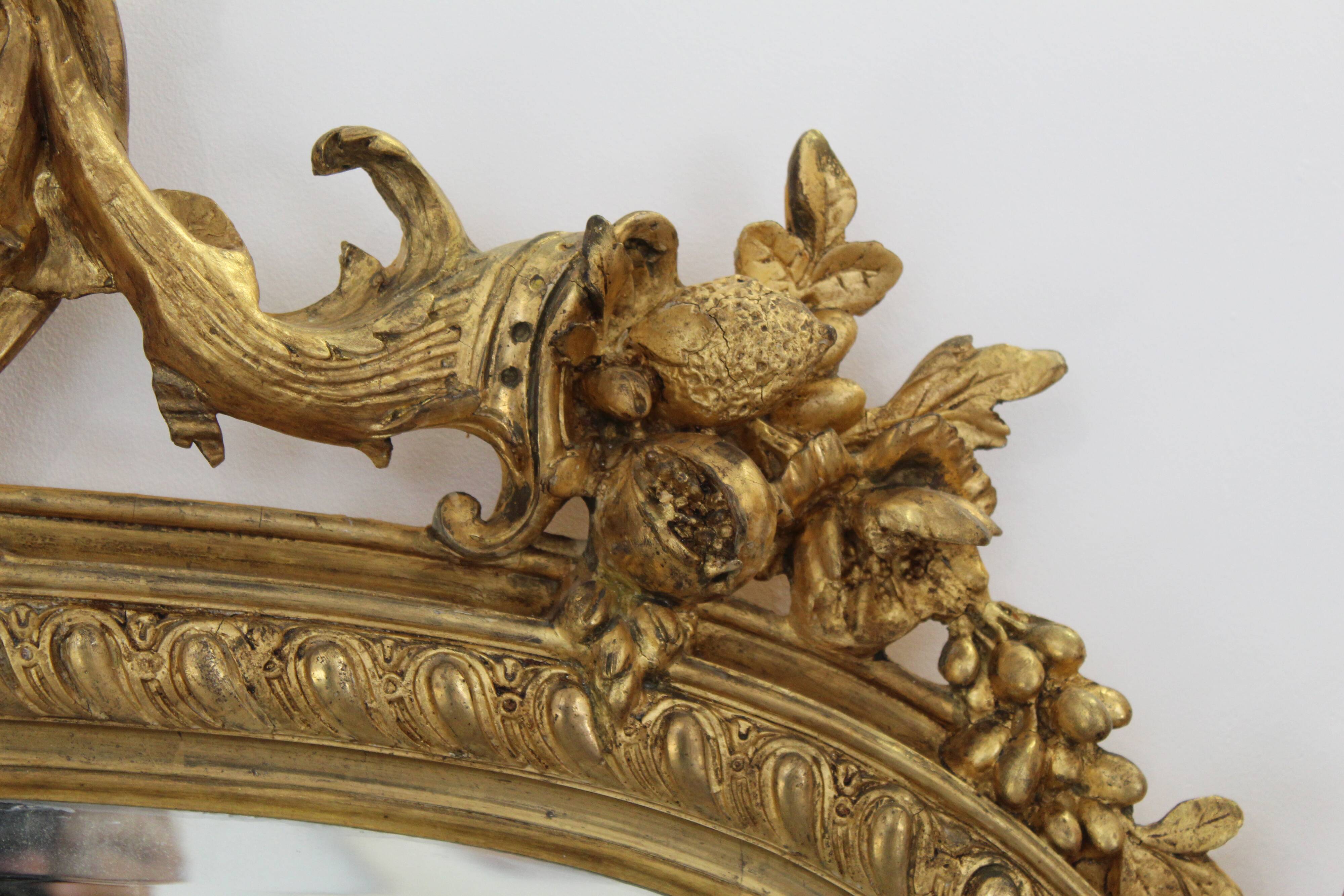 Large 19th-century wooden and gilt-studded mirror decorated with a cornucopia motif.