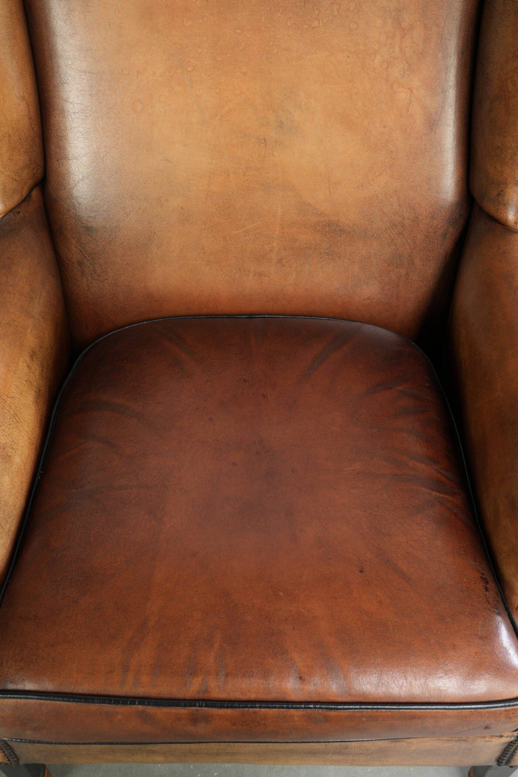 Sheepskin wingback armchair with patina finished with decorative nails