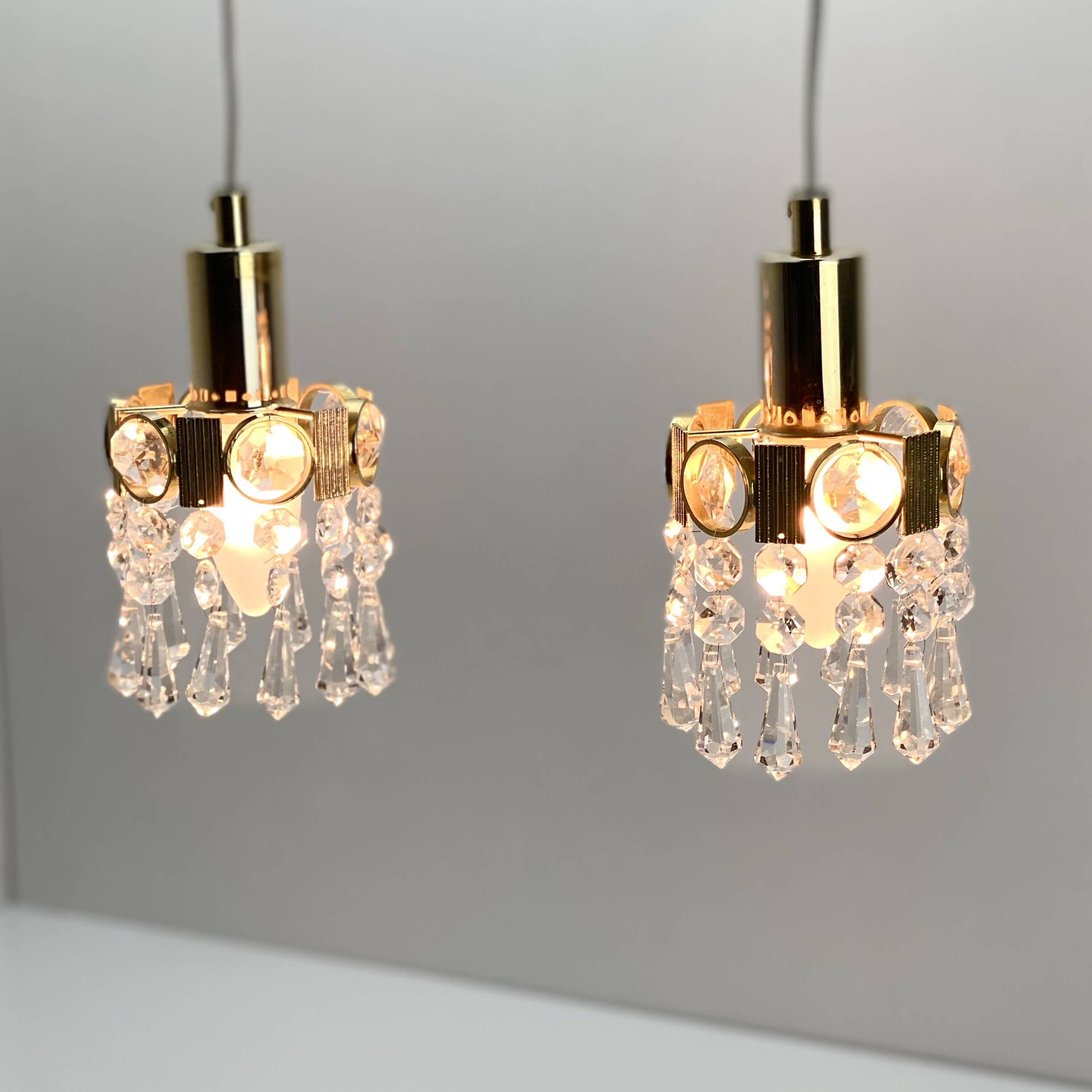 Two gold-plated brass and crystal pendant lights, by Palwa, 1960s design, Hollywood Regency.