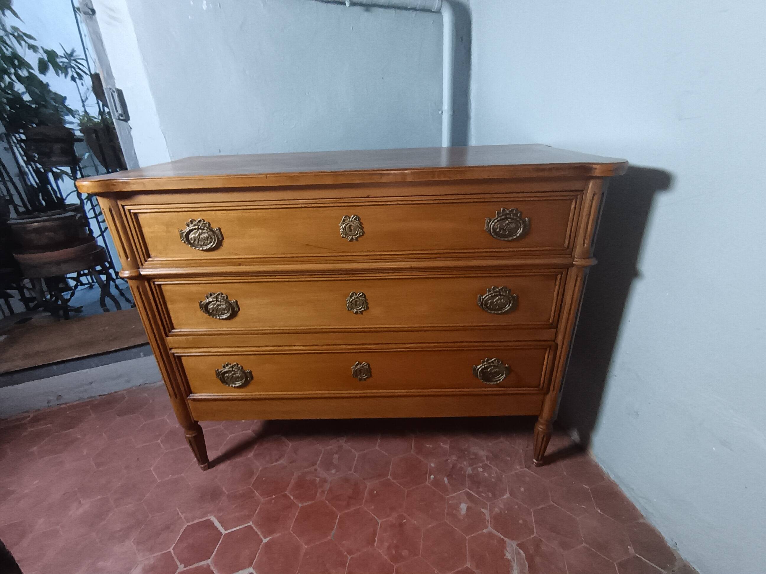 Commode de style Louis XVI ouvrant à trois tiroirs.