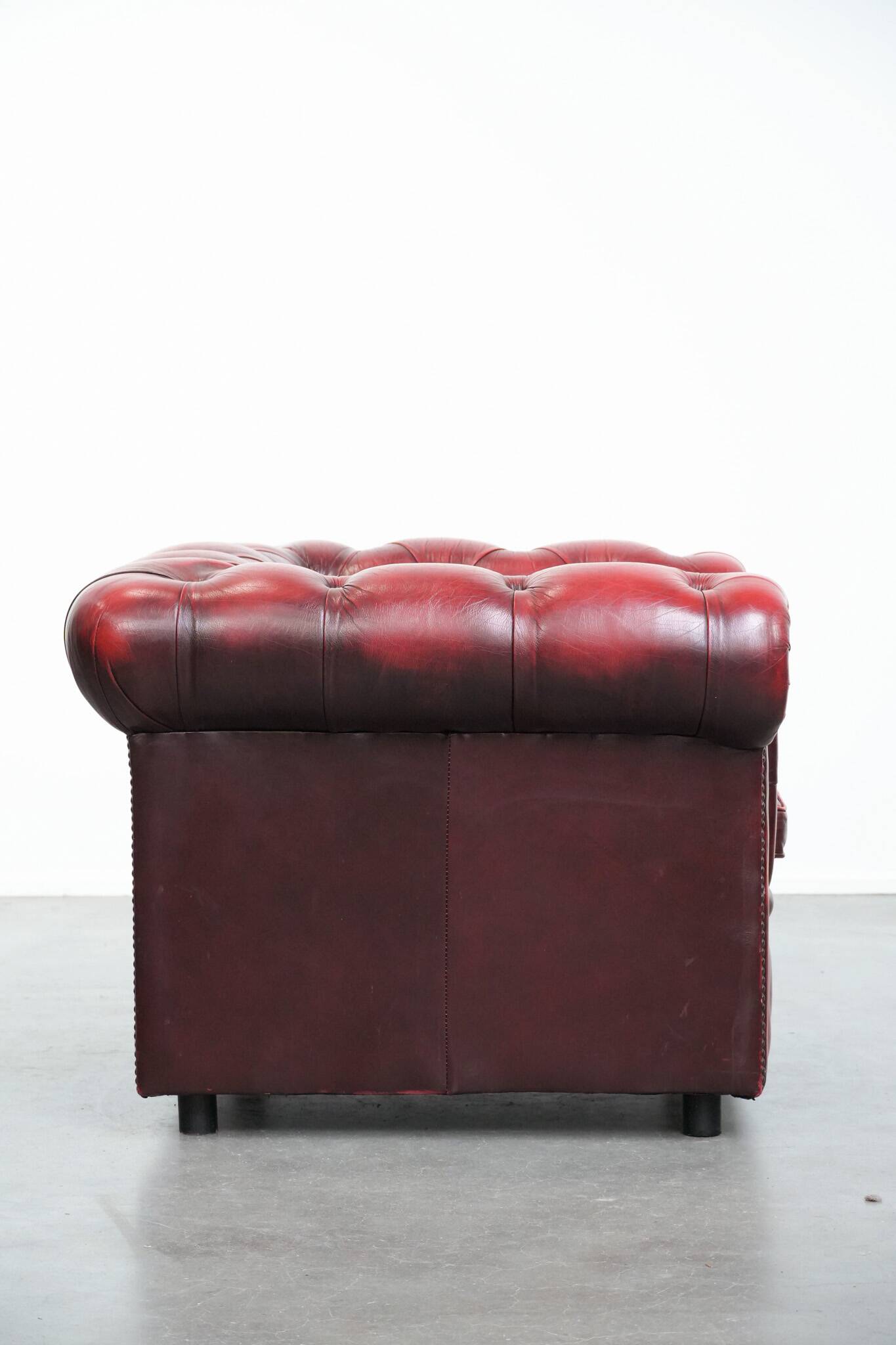 Red English cowhide Chesterfield armchair finished with decorative nails