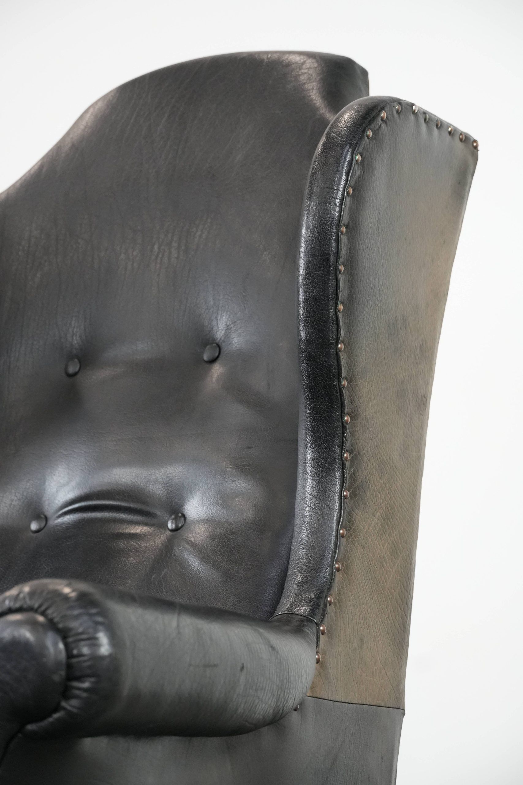 Antique black English cow leather wingback armchair from the 19th century