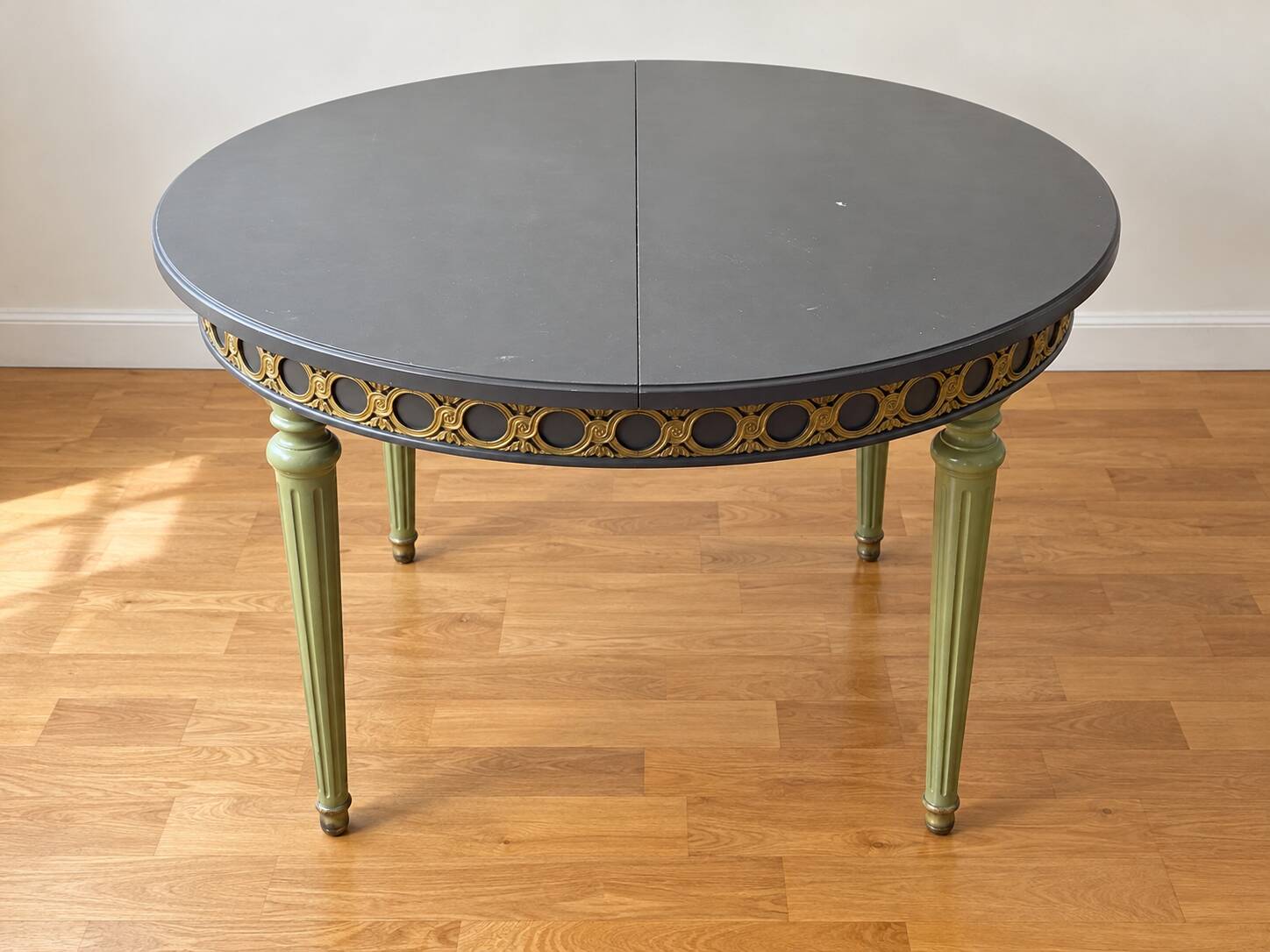 Extendable round table, 2 extensions, and 4 grey velvet chairs.