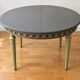 Extendable round table, 2 extensions, and 4 grey velvet chairs.