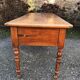 Antique cherry farmhouse table with turned legs and 2 drawers.