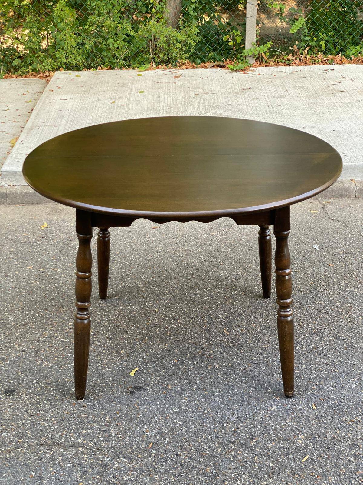 Extendable round table in solid wood with a dark oak satin finish.