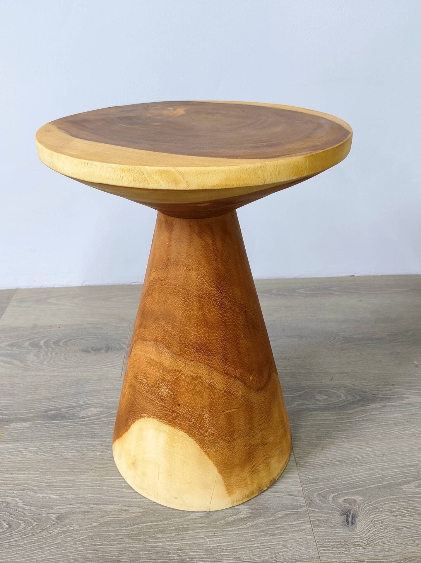 Minimalist side table in solid suar wood with conical legs.