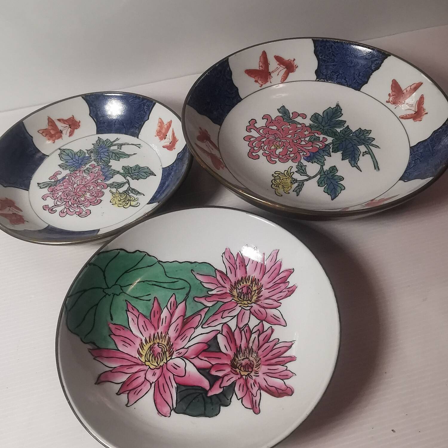 Three decorative plates in Chinese porcelain and brass from the 1960s. signed