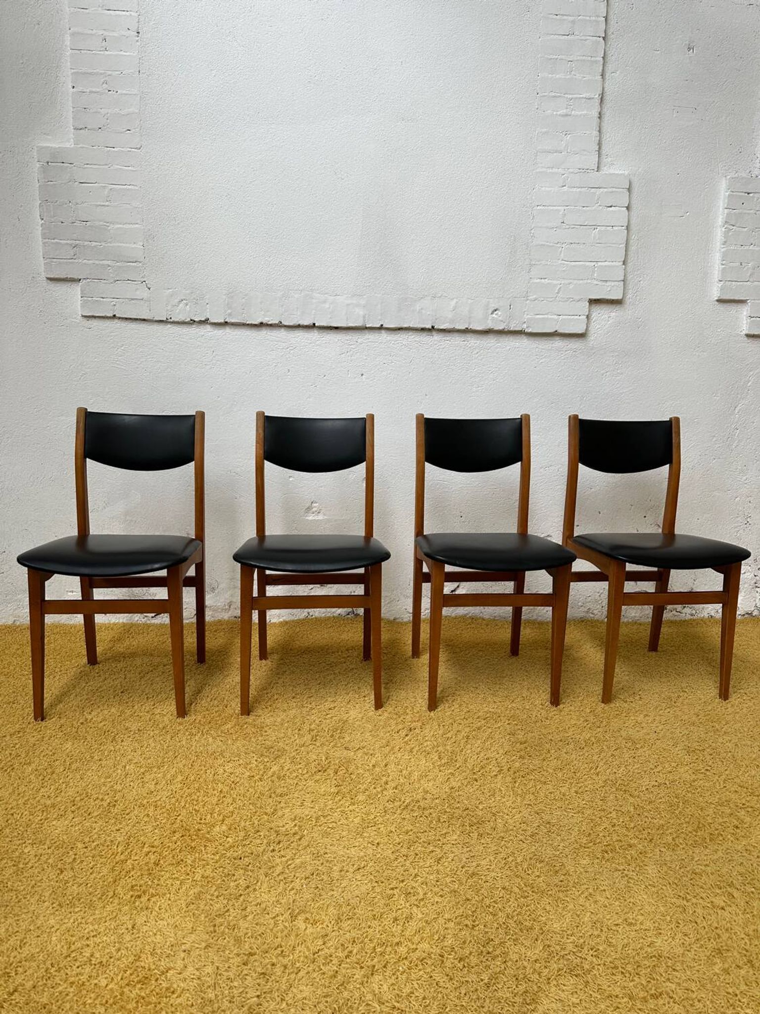 4 Scandinavian chairs in teak and black faux leather.
