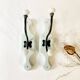 Antique metal and porcelain coat hooks, painted wooden support