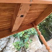 Folding drop-leaf table made of raw solid wood.