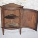 Antique wooden corner cabinet with a curved door.