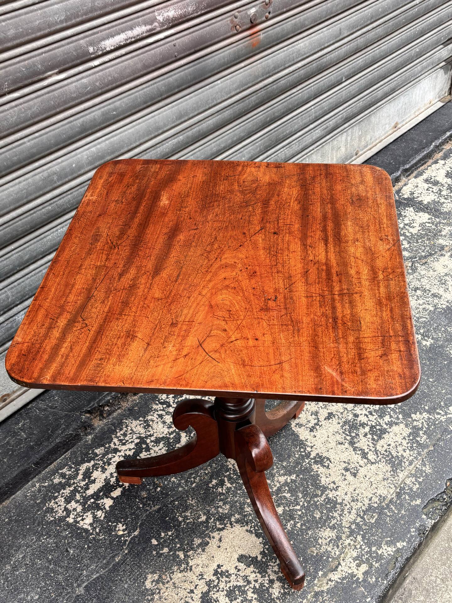 19th-century solid mahogany table with a tilting top and brass mechanism.