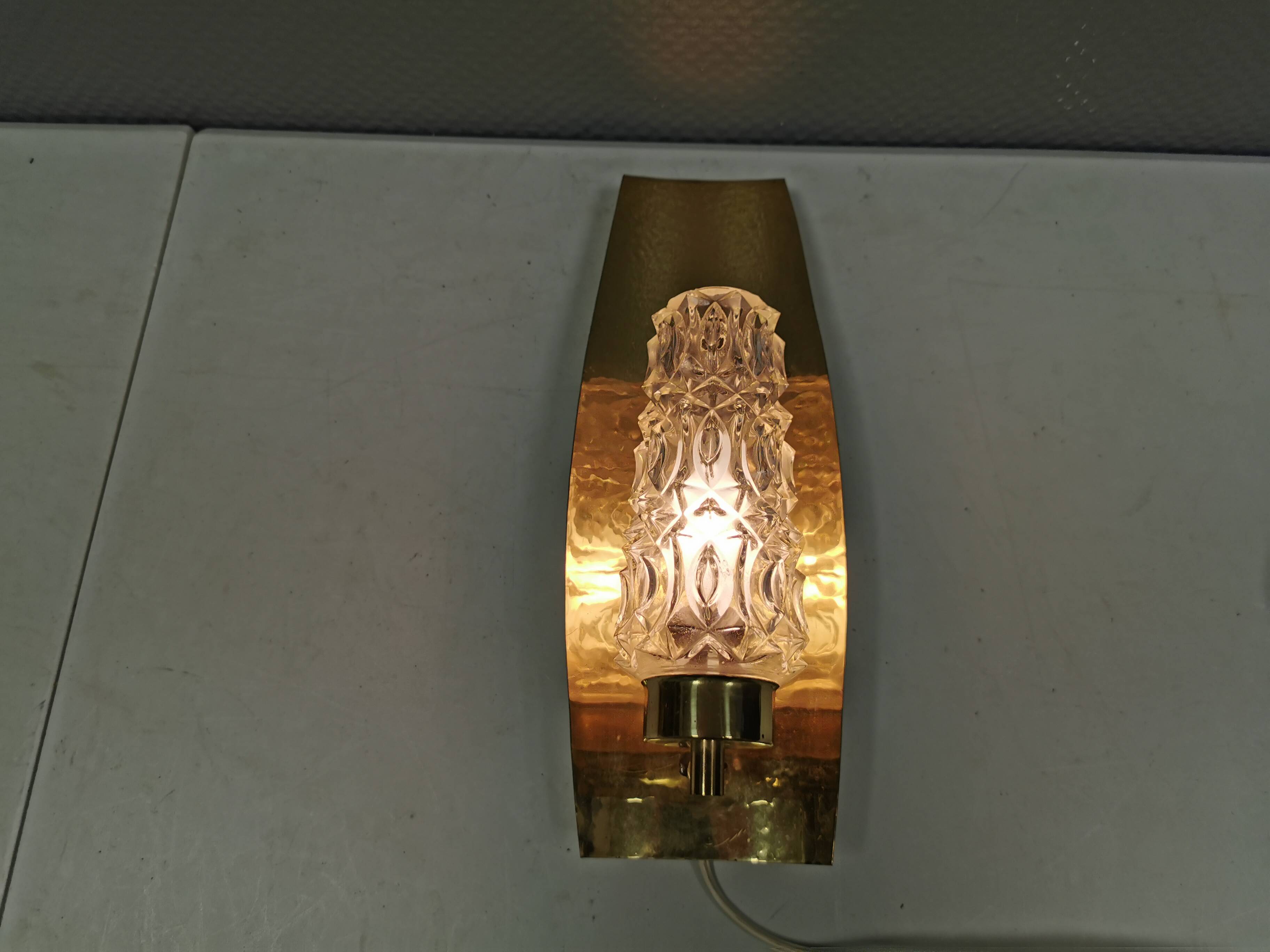 Older wall lamp in brass with hard pressed glass shade.