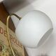 Antique swan neck wall light in brass with a white opaline tulip shade.