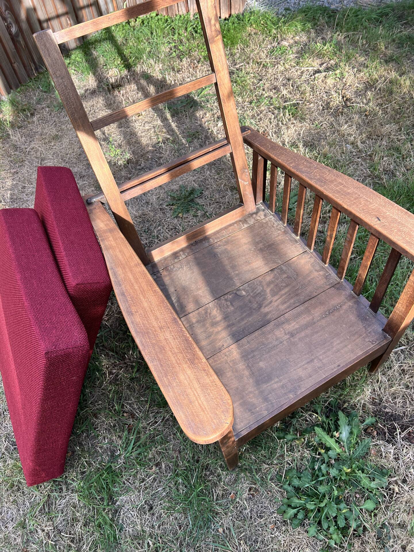 Morris chair with wooden frame and burgundy cushions.