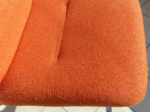 The 1970s orange armchair fabric and chrome metal