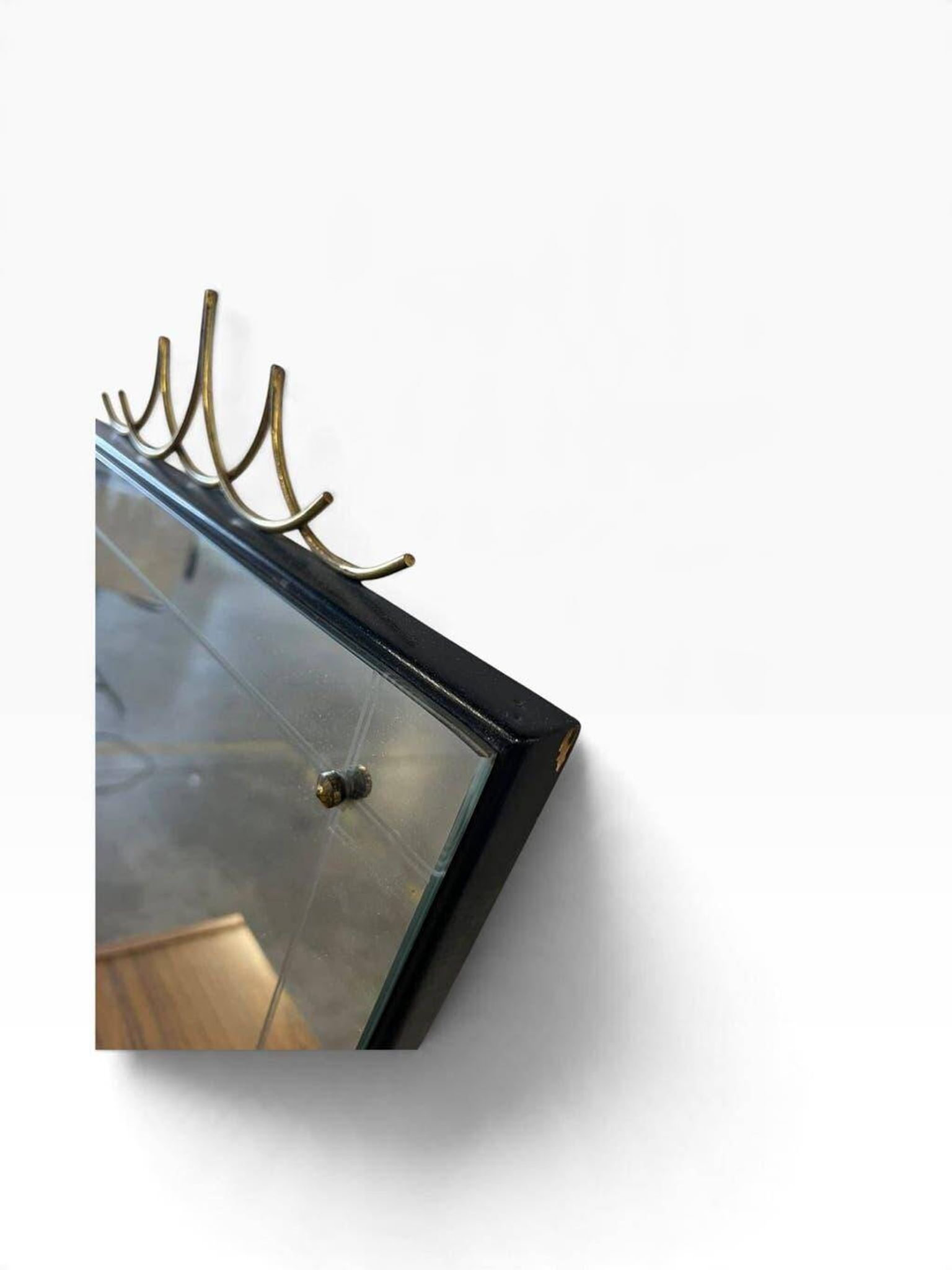 Elegant black wall mirror in vintage style with brass accents.