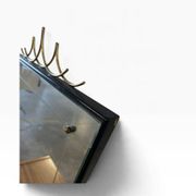 Elegant black wall mirror in vintage style with brass accents.